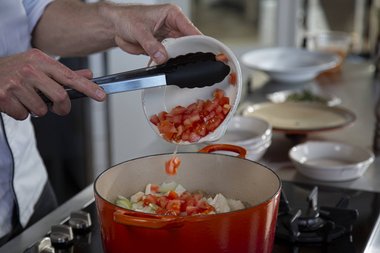 Add more vegetables to the pan.